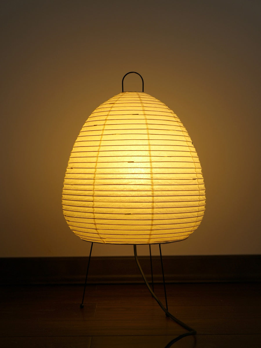 Akari 1A Table Lamp — lit in a dark room on wood flooring, warm light through the horizontal ribs — Captains Bamboo