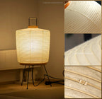 Akari 2A Table Lamp — lit lamp on a wood floor near a panel, with washi texture insets — Captains Bamboo