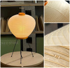 Akari 3A Table Lamp — lit lamp on a round wood table in a shop, washi detail insets — Captains Bamboo