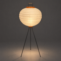 Akari 10D Floor Lamp — same shade lit, casting a warm pool of light onto the studio floor — Captains Bamboo