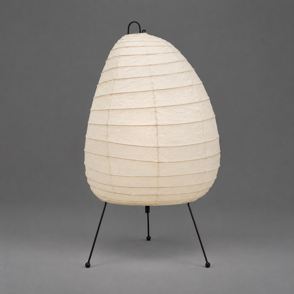 Akari 1N Table Lamp — unlit egg-shaped shade on three thin wire legs, grey studio backdrop — Captains Bamboo