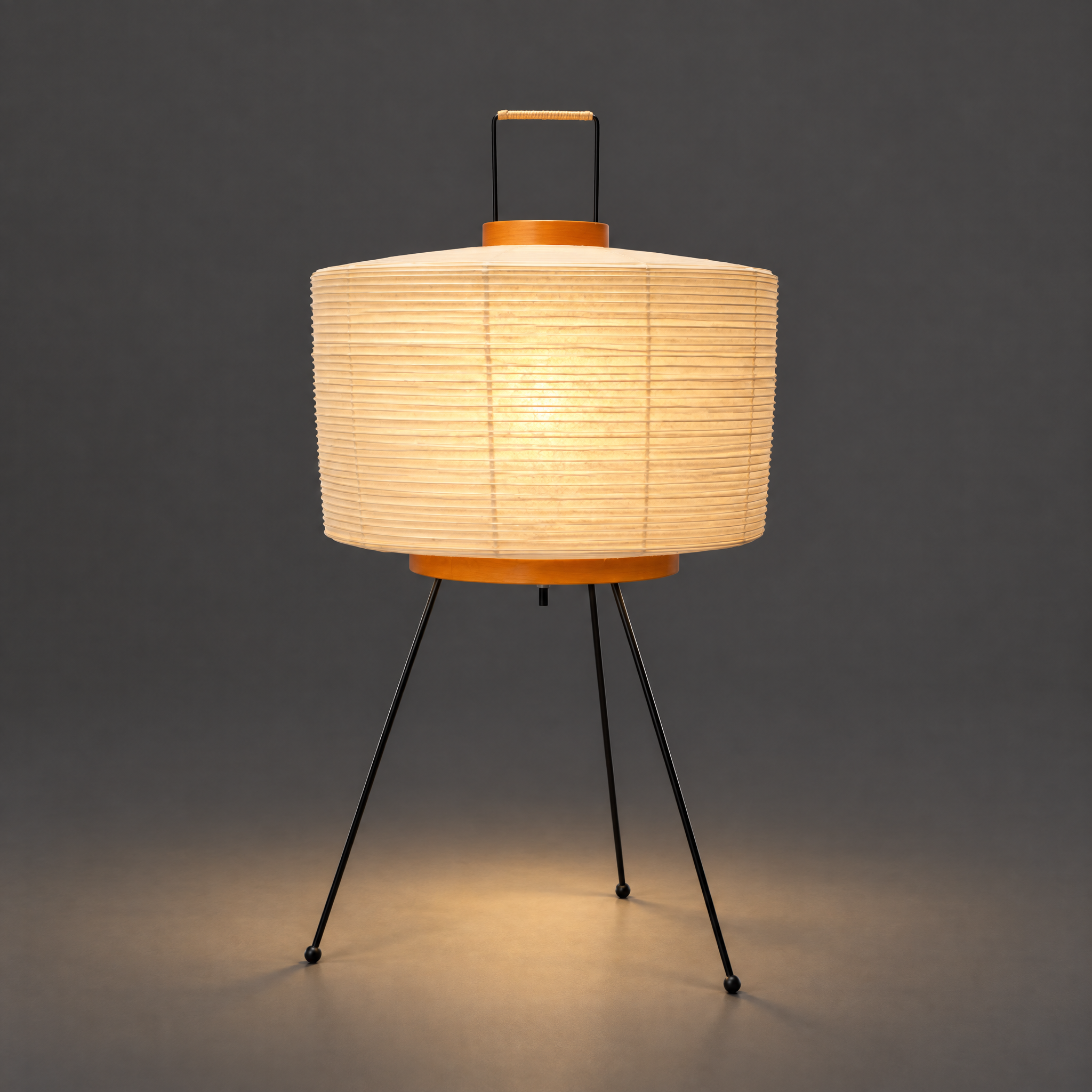 Akari 6A Washi Table Lamp — lit drum shade glowing warm in a dark studio, light spreading on the floor — Captains Bamboo