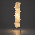Noguchi UF4-33N Akari Floor Lamp — lit version of the wavy column shade, warm glow, dark studio backdrop — Captains Bamboo