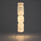 Akari UF4-L9 and UF4-L6 Floor Lamp — the same column lamp lit, casting a soft shadow on a dark grey wall — Captains Bamboo
