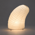 Glow Akari VB-13T Floor Lamp — lit, warm glow low on the same grey studio floor — Captains Bamboo