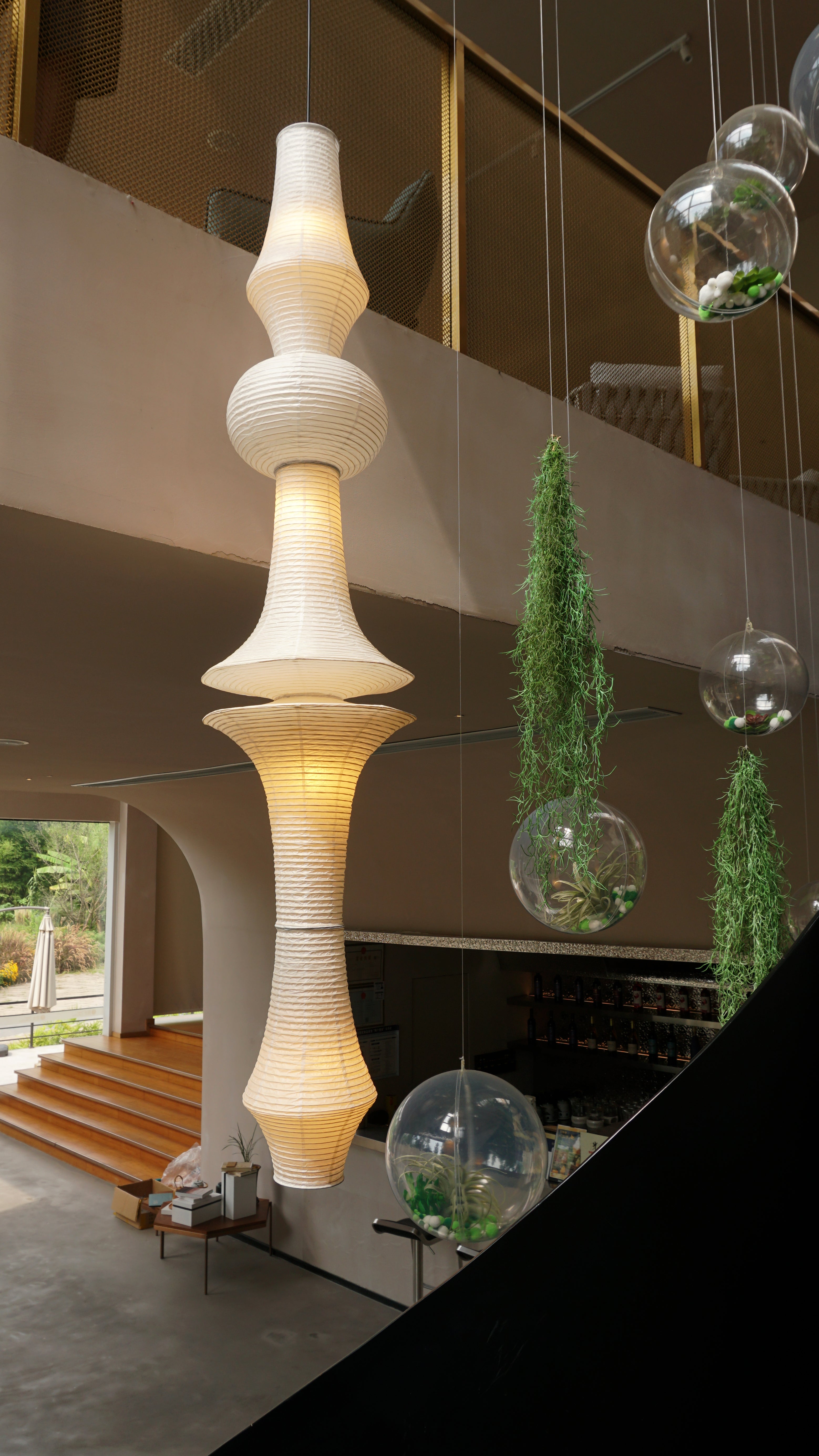 Akari hanging lamp above Victorian staircase creating vintage ambience