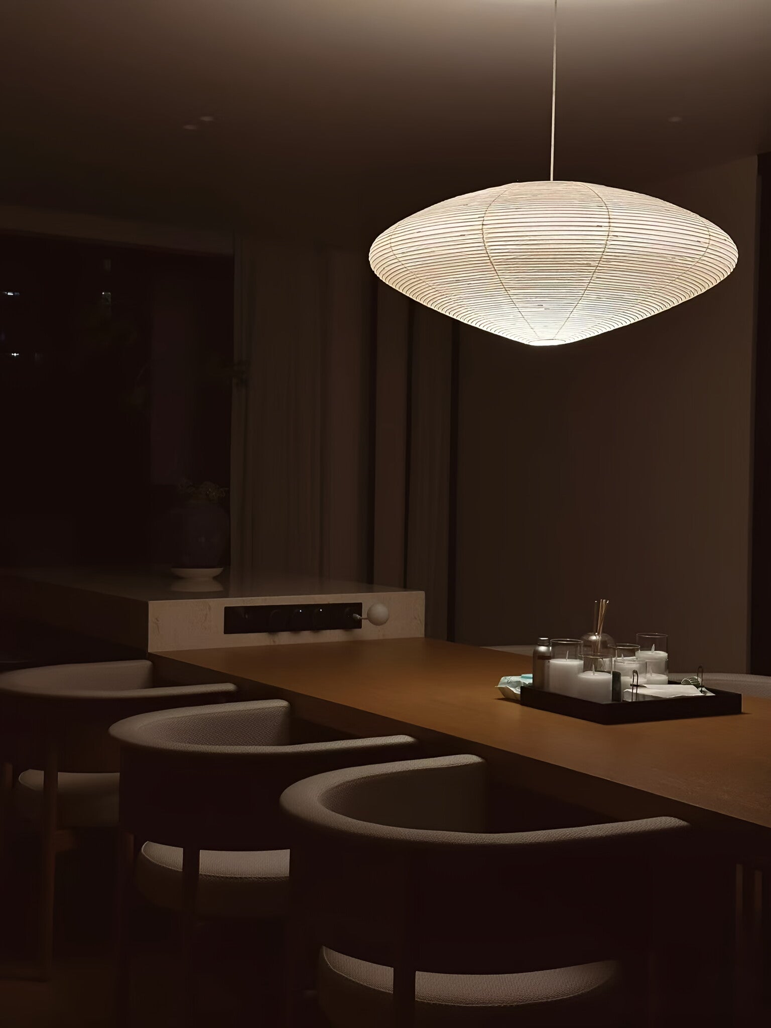 Akari pendant lamp casting warm ambient light in living room